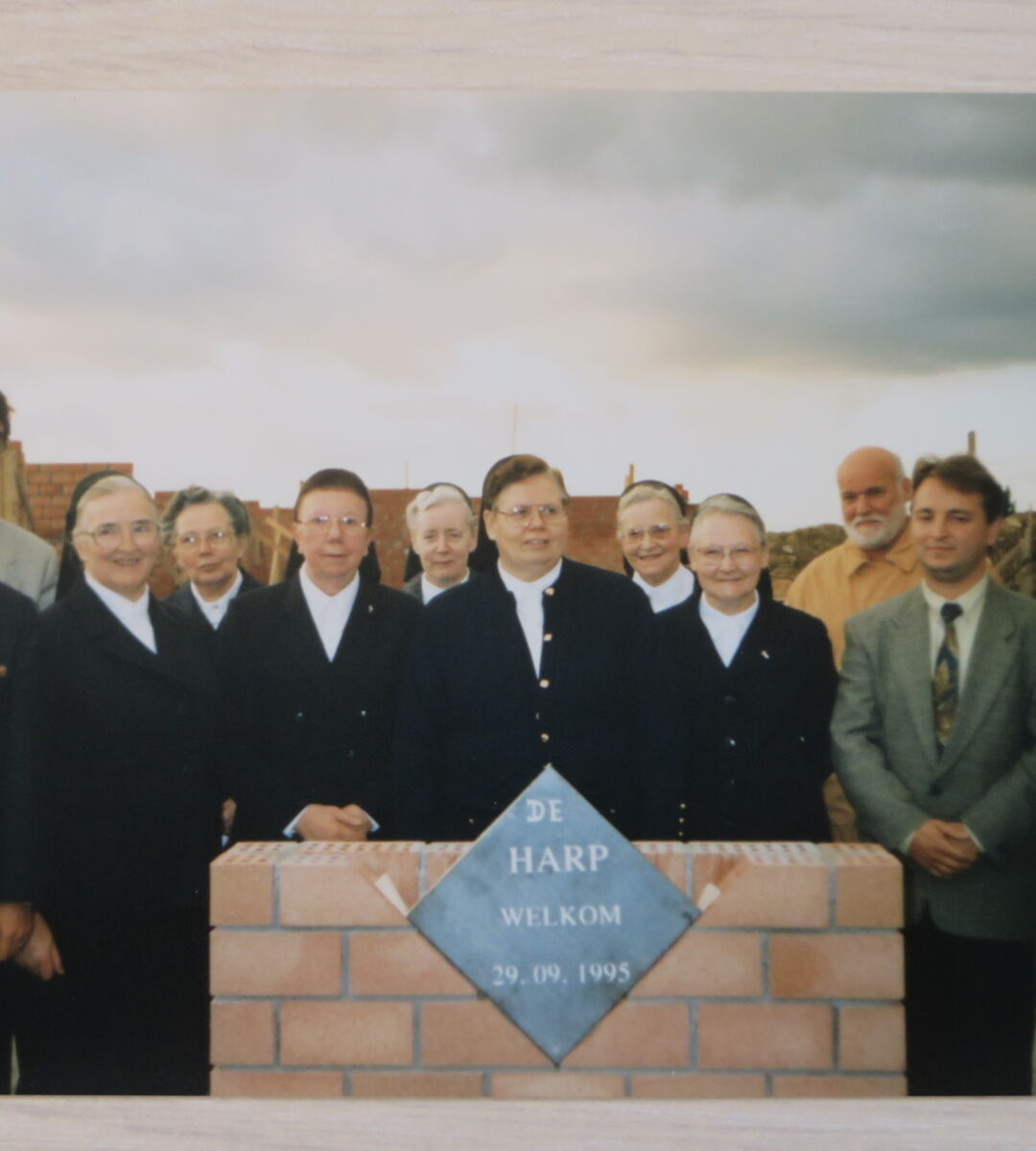 Groepsfoto van eerstesteenlegging afdeling De Harp